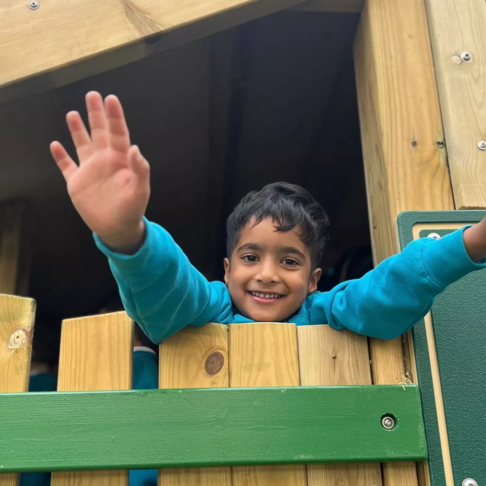 A pupil at Canary Wharf Primary East Ferry enjoying outdoor play in the school's timber adventure playground.